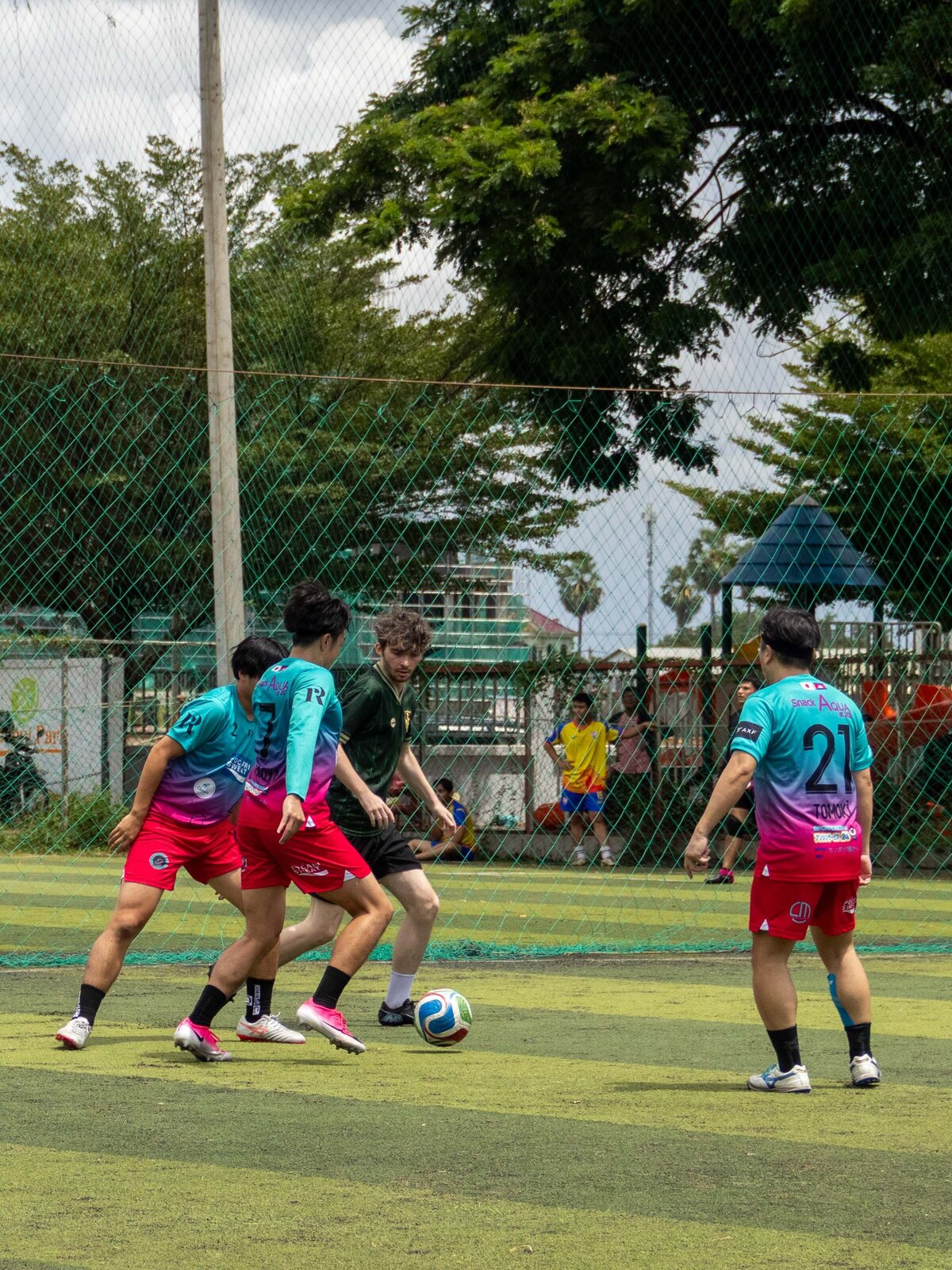 Players competing in a soccer match on the outdoor pitch at DIB Club in Phnom Penh