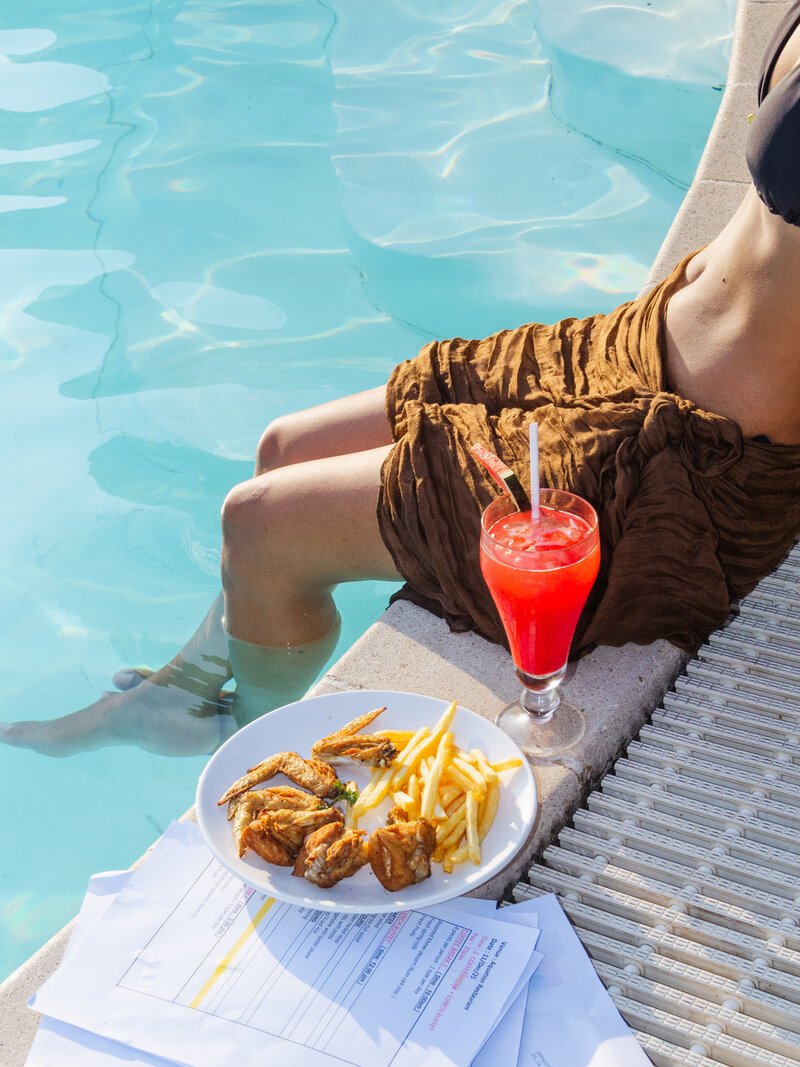 Chicken wings, French fries, and a red cocktail by the swimming pool at DIB Club, Phnom Penh.
