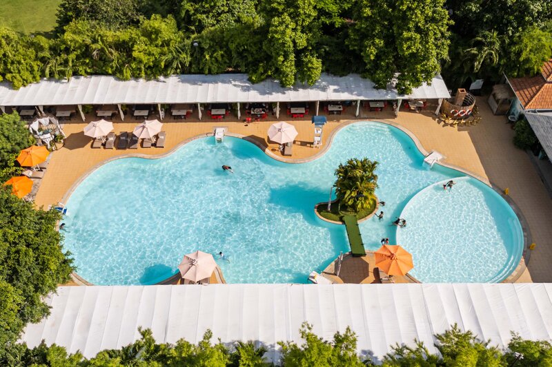 Overhead view of the full outdoor swimming pool layout with umbrellas and sun loungers.