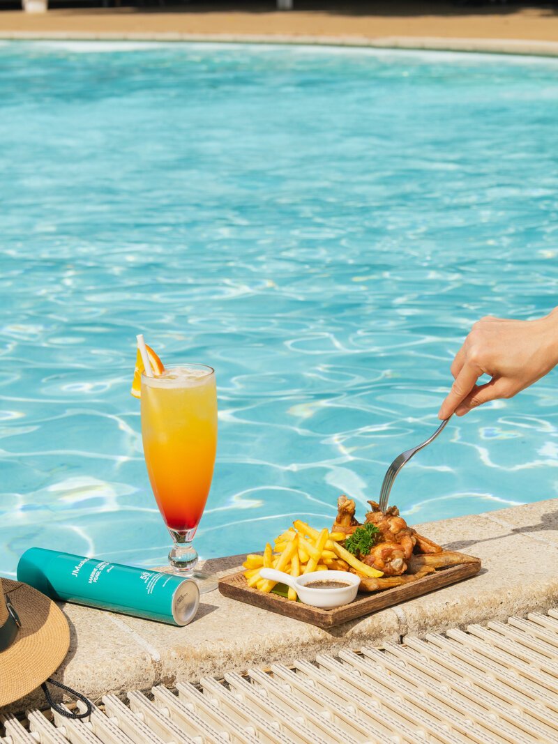 Platter of fried chicken, French fries, and a fruit cocktail sitting on the pool ledge, DIB Club, Phnom Penh.