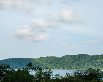 Panoramic view from the Hillside rooms looking out over lush green treetops and ocean at Island Center Point hotel, Koh Rong Sanloem.