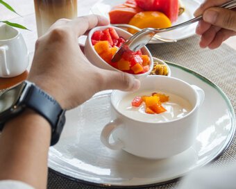 Guest adding fresh mix fruits into a bowl of yogurt at Island Center Point hotel, Koh Rong Sanloem.