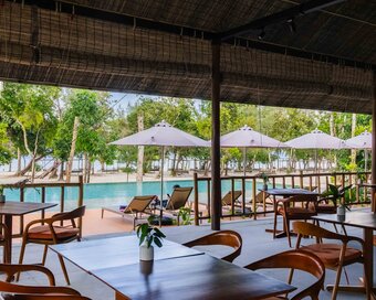 Dining tables and chairs inside the open-air restaurant overlooking the pool of Island Center Point hotel, Koh Rong Sanloem.