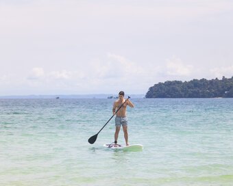 Island-goer balancing on a paddleboard at Island Center Point hotel, Koh Rong, Sanloem.