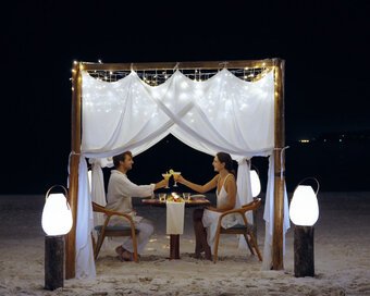 Couple having a candlelit seaside dining at Island Center Point hotel, Koh Rong Sanloem.