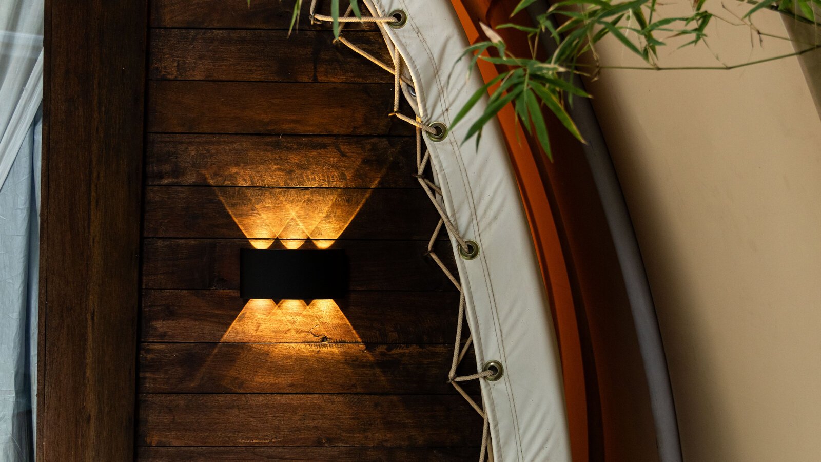 Close-up shot of the textured wall with light fixture mounted on dark wooden panel.
