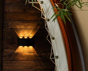 Close-up shot of the textured wall with light fixture mounted on dark wooden panel.