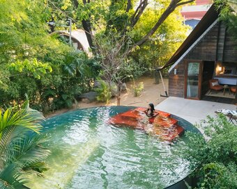 Steel-and-wood jungle hideaway centered around red-stepped circular pool.