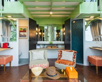Living room inside the water tower with two chairs, a glass table, and a vanity in the center.