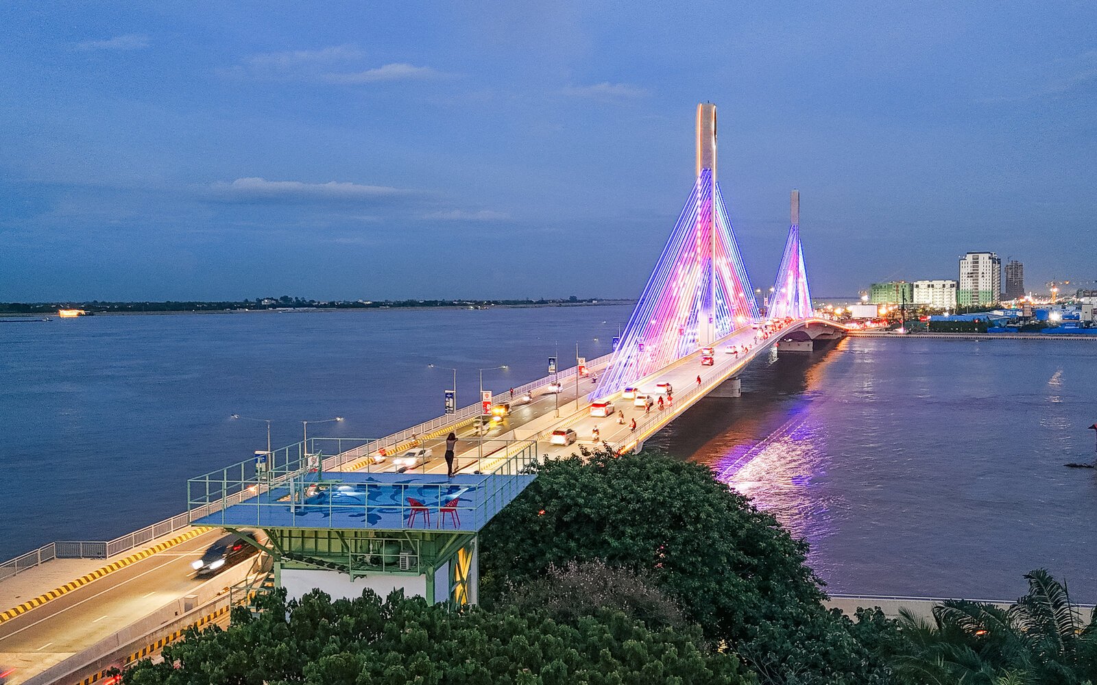Water Tower's rooftop pool, overlooking the illuminated bridge crossing a wide river.