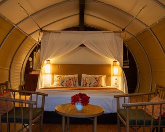 maadest, jungloo (Jungle Igloo) unit, interior view with bed and wooden chairs & table set