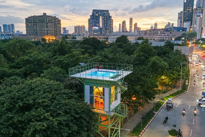 a repurposed water tower emerging from the trees as a suite with private pool in Phnom Penh