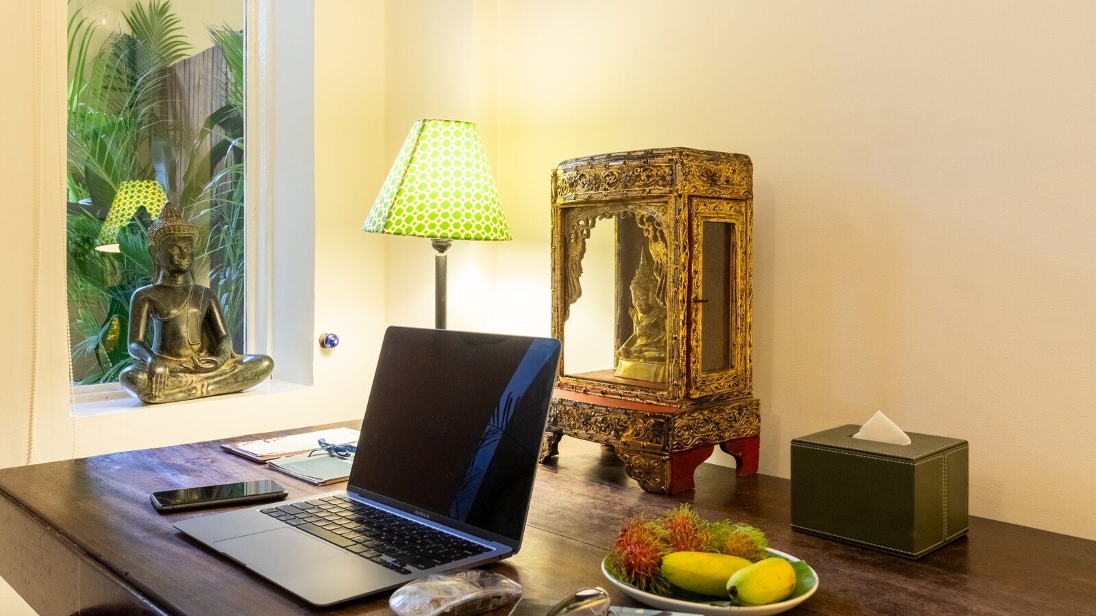 Work desk with laptop, table lamp and decorative pieces in a Deluxe Double room at Pavilion Phnom Penh
