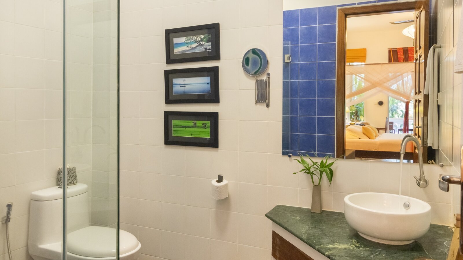 Deluxe Double bathroom with walk-in shower, basin and mirror at Pavilion Phnom Penh
