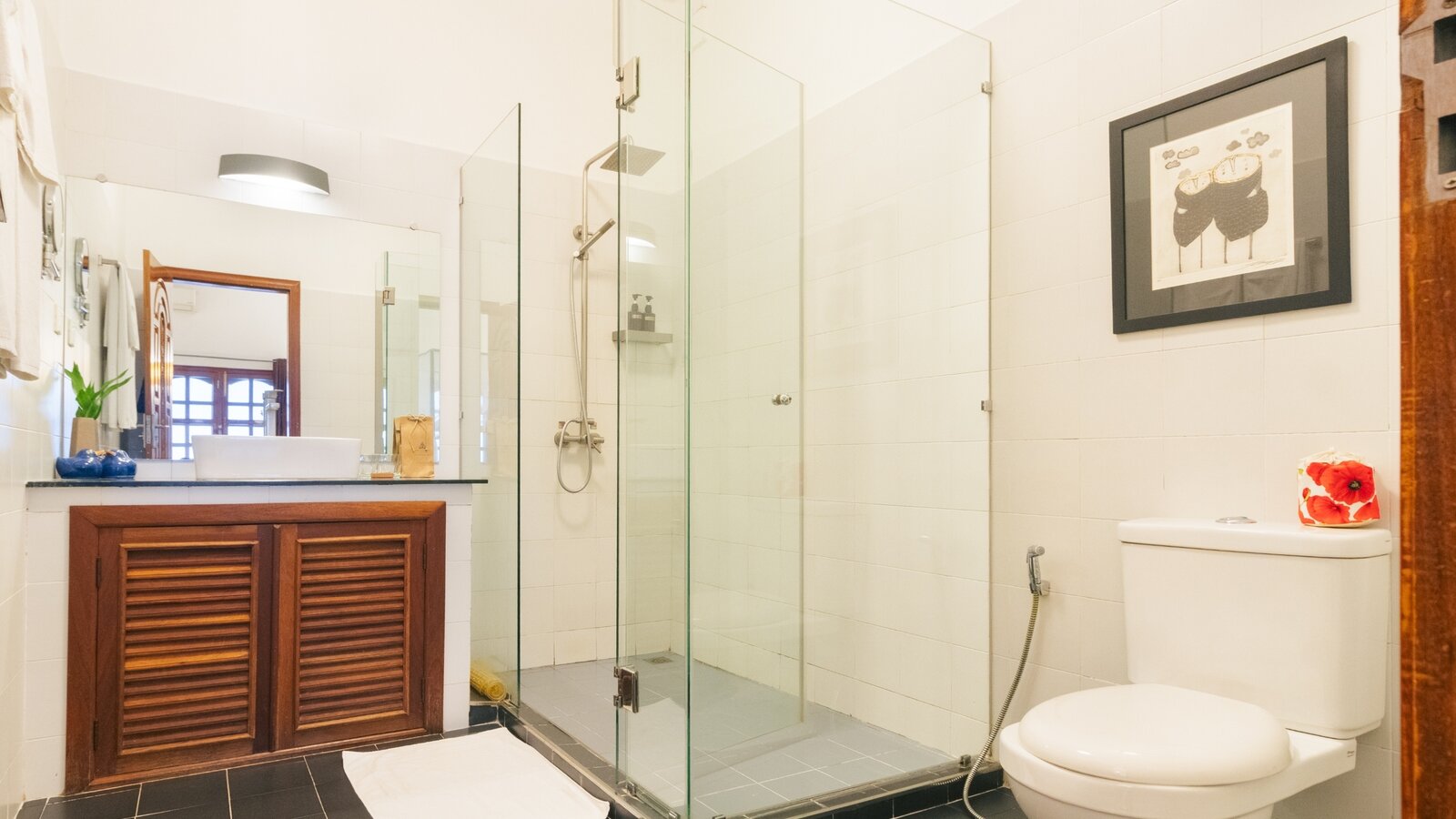 Deluxe Double bathroom with glass-enclosed walk-in shower and vanity at Pavilion Phnom Penh