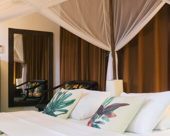 King bed with mosquito net and botanical cushions in the Private Jacuzzi bedroom
