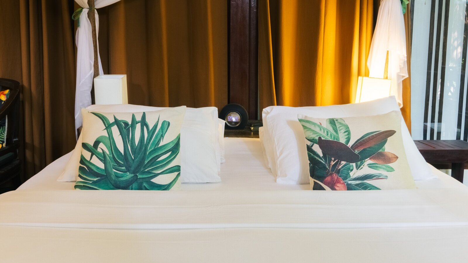 Front view of the king bed with mosquito net and botanical cushions in the Private Jacuzzi bedroom