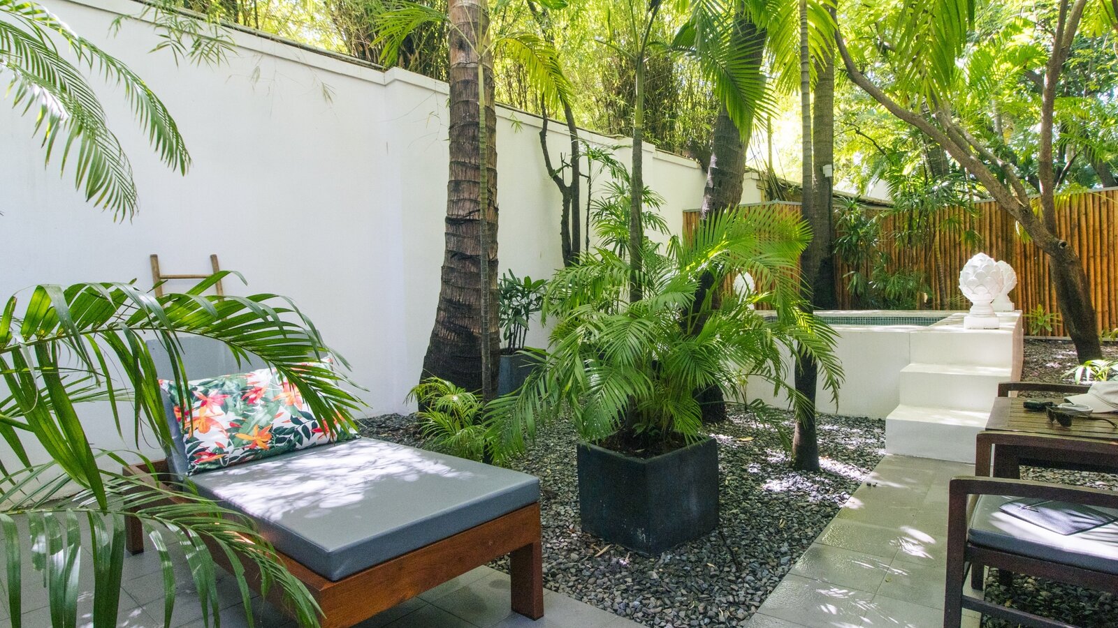 Private open-air jacuzzi surrounded by tropical garden with the guest room beyond
