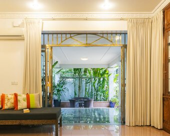 Spacious Pavilion suite living area opening onto a terrace surrounded by tropical plants