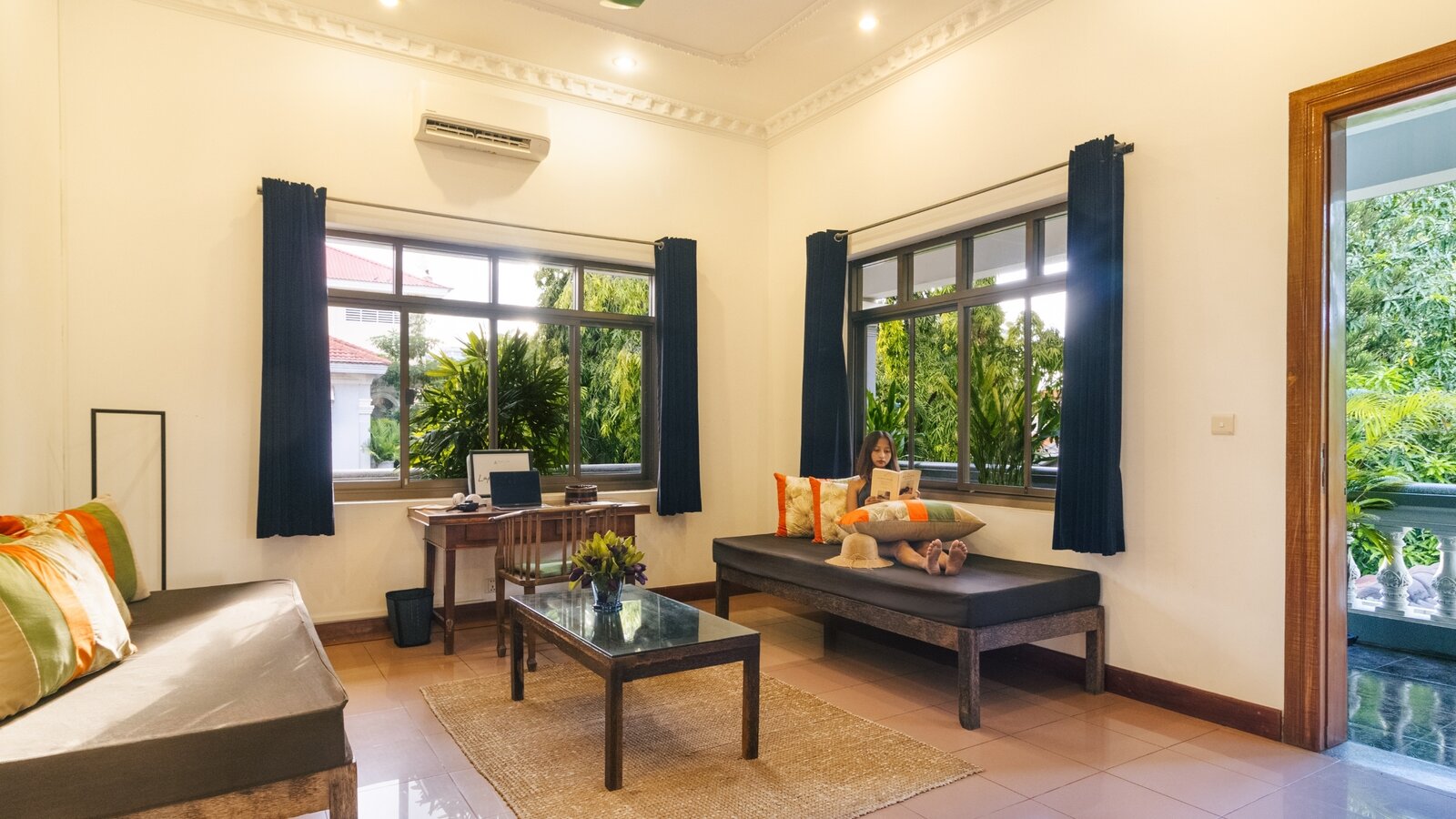 Spacious Pavilion suite sitting area with day beds, writing desk and large windows overlooking the gardens
