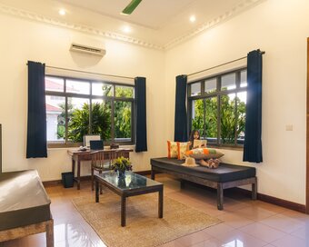 Spacious Pavilion suite sitting area with day beds, writing desk and large windows overlooking the gardens