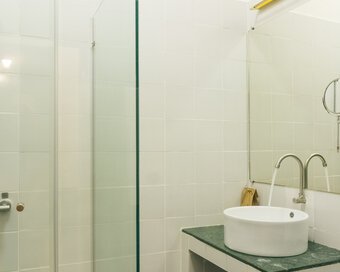 Pavilion suite bathroom with walk-in shower, round basin and wall-mounted mirror