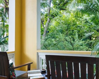 Private balcony with seating overlooking the tropical garden from a Superior Double Room at Pavilion Phnom Penh