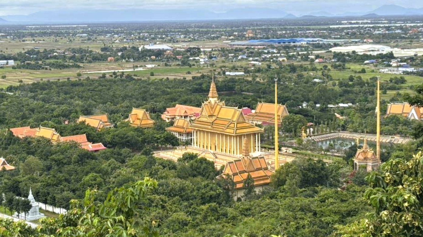 Temple rooftops and forested hills from a viewpoint overlooking Oudong.