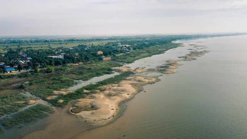 Sandbanks trace the river’s edge beside rural communities and wetlands.