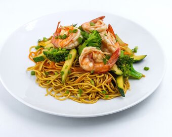 yellow noodles with shrimp and broccoli.