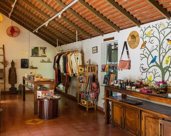 Shop interior featuring artisan goods, textiles, accessories and a bird mural along one wall.