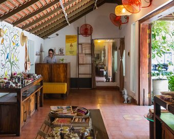 Display tables with artwork, clothing and handcrafted items inside Pavilion Hotel, Cambomania Shop.