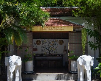 Entrance to Cambomania Shop by Pavilion Hotel framed by bamboo plantings and white elephant sculptures.