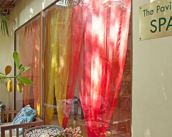 Entrance to Pavilion Spa with colourful curtains and outdoor seating area.