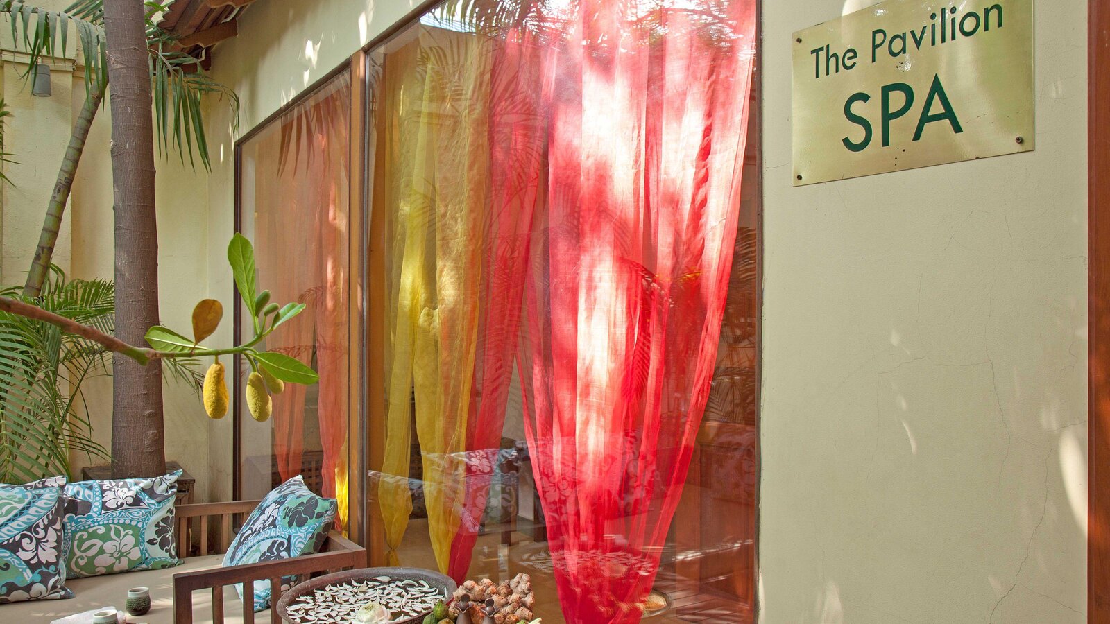 Entrance to Pavilion Spa with colourful curtains and outdoor seating area.