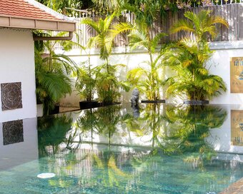 Reflections on the sun pool beside the Pavilion sign and planted border.