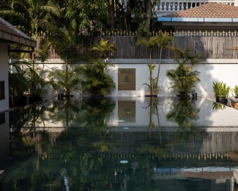Sun Pool with sun bed loungers and Khmer guardian lions display.