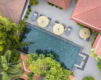 Top-down view of the Sun Pool with sun bed loungers and surrounding gardens.