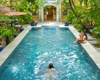Main pool with swimmers at Pavilion Heritage Oasis Hotel, Phnom Penh