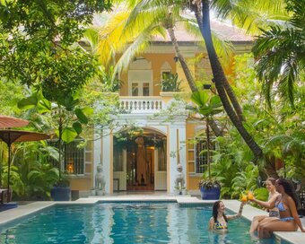 Main pool at Pavilion Heritage Oasis Hotel, Phnom Penh, with 3 guests enjoying a drink