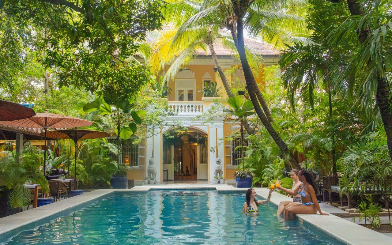 Main pool at Pavilion Heritage Oasis Hotel, Phnom Penh, with 3 guests enjoying a drink