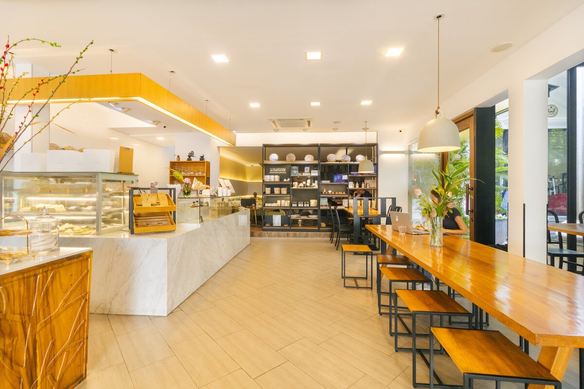 Interior look of Le Café, with long dining table, retail shelf and bakery counter.